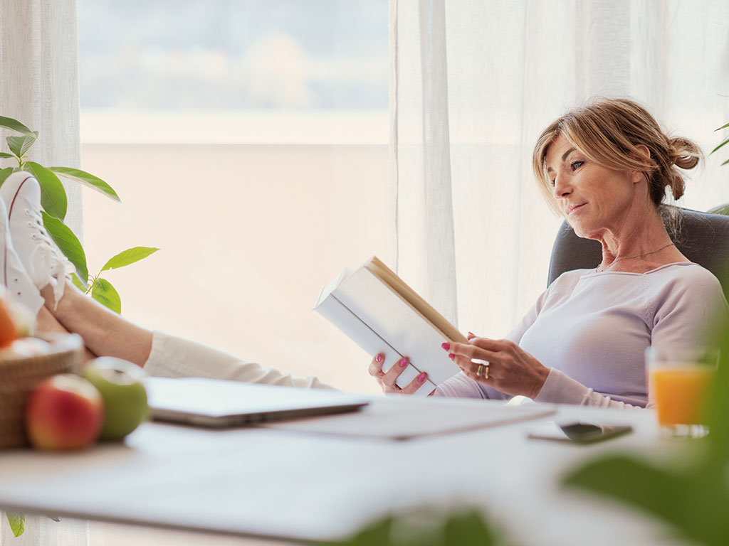 Woman-Reading-with-Feet-Up-on-Desk